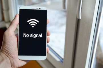 A person sees a white inscription on a black smartphone display that holds in his hand. No signal