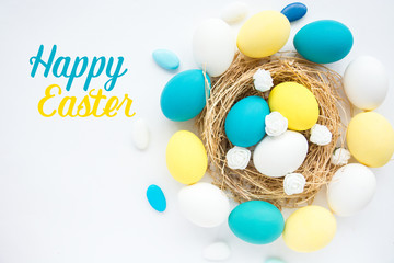Multi-colored Easter eggs in nest on wooden background, selective focus image. Happy Easter card 