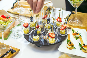 Sweet candy bar closeup. Pieces of berry and fruits on canape. Table decoration process.