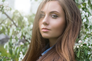 красивая молодая женщина с густыми длинными волосами стоит в весеннем парке  © lufotolab