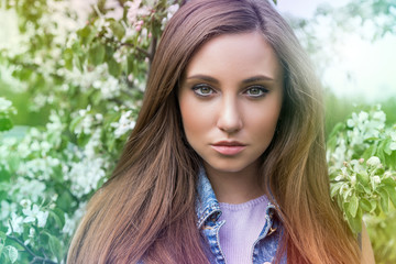 красивая молодая женщина с густыми длинными волосами стоит в весеннем парке  © lufotolab