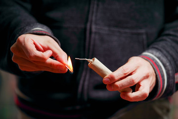 Close up of man hand lighting up a firecrackers in a burred background