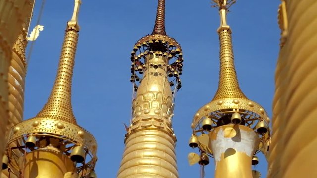 The close-up of hti ornamental umbrellas on the top of golden stupas of Inn Thein Buddha image Shrine in Indein (Inn Thein) village, Inle Lake, Myanmar.