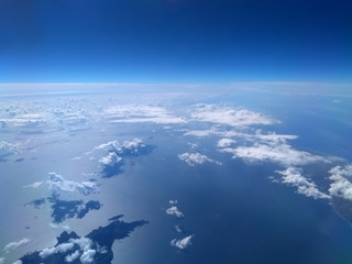 Fototapeta premium aerial view of bright blue sea and sky with white clouds casting shadows