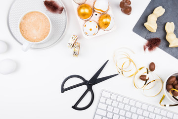 Happy Easter! Stylish stationery background with chocolate eggs. gold and white eggs and accessories on white background. Table decorating for holiday. Feminine flat lay. Office easter concept.