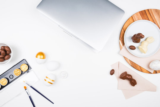 Happy Easter! Stylish stationery background with chocolate eggs. gold and white eggs and accessories on white background. Table decorating for holiday. Feminine flat lay. Office easter concept.