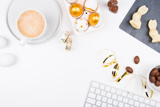 Happy Easter! Stylish stationery background with chocolate eggs. gold and white eggs and accessories on white background. Table decorating for holiday. Feminine flat lay. Office easter concept.