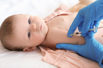 Obraz na płótnie Canvas Doctor vaccinating baby in clinic