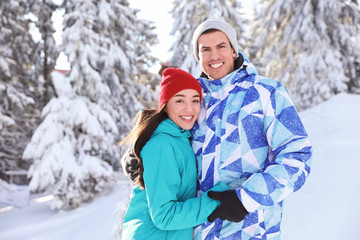 Fototapeta na wymiar Happy couple at beautiful snowy resort. Winter vacation