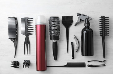 Flat lay composition with professional hairdresser tools on wooden background
