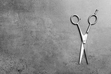 Professional hairdresser scissors on grey background, top view