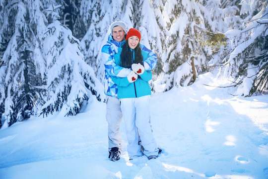 Happy couple at beautiful snowy resort. Winter vacation