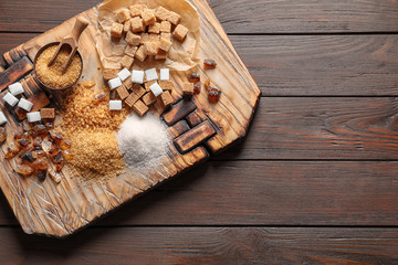 Different types of sugar on wooden board