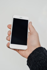 Close up on hand using mobile phone with blank copyspace display for advertising text message or content mockup background. Professional payment technology, game playing, video filming or photography