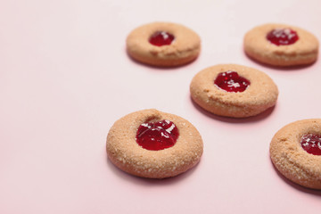 Tasty cookies with jam on color background