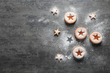Tasty Linzer cookies with jam on grey background