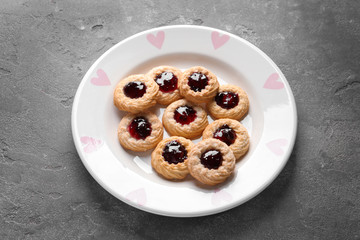 Tasty cookies with jam on plate