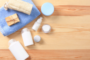 Flat lay composition with body care cosmetics on wooden background