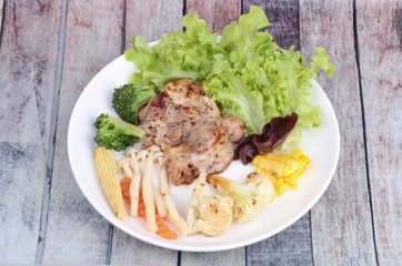 Chicken steak and grilled mixed vegetables .