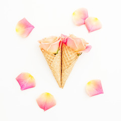 Rose flowers in waffle cones and petals on white. Romantic moment. Flat lay, top view