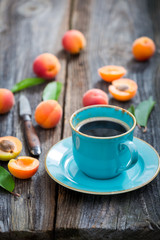 Blue coffee and orange plums in summer garden
