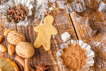 Ingredients and molds for making classic ginger biscuits on a wooden table.