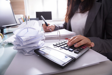 Businesswoman Calculating Invoice