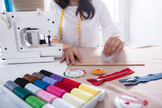 Fashion Designer Measuring Fabric With Ruler