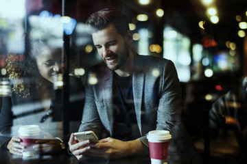 Casual man using mobile phone in the cafe