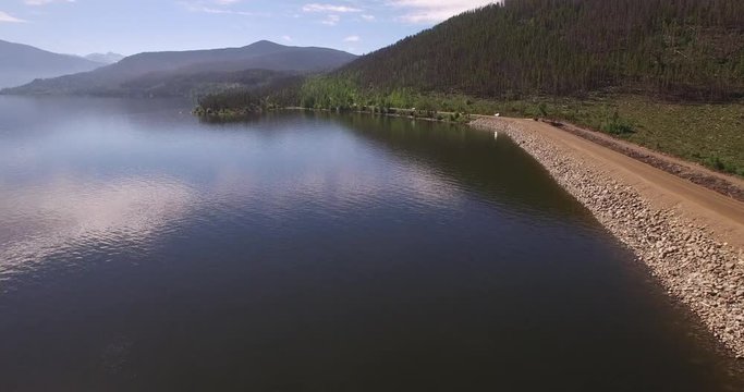 FLyin over lake granby near road - Drone Aerial Video 4K Colorado Rocky Mountains, Colorado river, Mountain dam at lake granby,  beautiful water reflection, spring, pristine water,