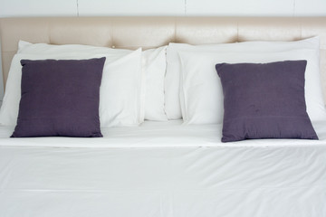 white bedding and grey pillow on the bed in hotel room. soft white pillows and comfortable bed