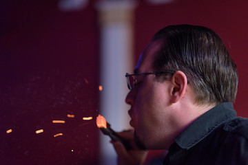 Fototapeta premium Male model smoking hookah in a night club