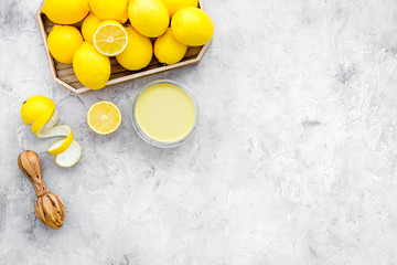 Lemon curd. Sweet cream for desserts near lemons and juicer on grey background top view copy space