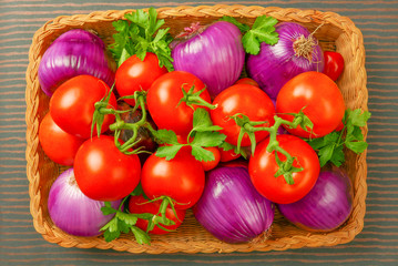 Basket of bright red tomatoes and purple onions