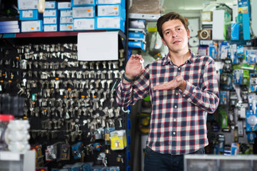 worker in hardware store trading goods and keys in uniform