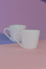 tableware mockup. Minimalist cup Mockup. Two white cups on a trendy graphic background in pastel colors.white cup on trend lilac pink graphic background.  copy space