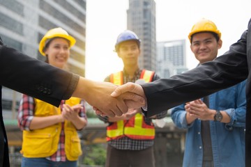 Businessman shake hand with engineers celebrating success