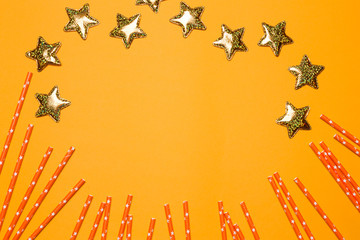 bright tubes for drinks and gold stars on a yellow background, concept of a merry holiday