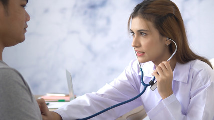 Female Doctor talking with young patient man in hospital