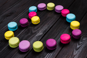 Bright almond cookies laid out on a dark wooden background in the form of heart