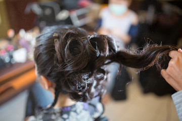 Professional hairdresser makes hairstyle bride for wedding day celebrate