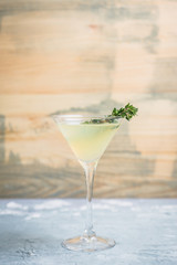 Tasty bitter cocktail with thyme in martini glass. Selective focus.