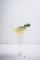 Tasty bitter cocktail with thyme in martini glass. Selective focus.