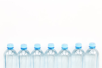 Drinking water in bottles on white background top view copy space