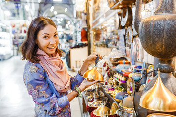 Woman tourist walking among countless shops in Grand Bazaar market in Istanbul. Shopping and travel...
