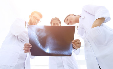 Obraz premium three doctors studying the patient's X-ray film