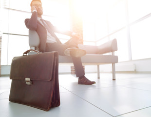 businessman holding his briefcase in office - obrazy, fototapety, plakaty