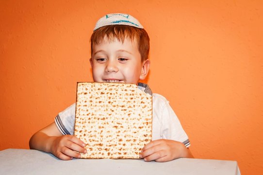 Happy little Jewish child with a kippah on his head looking forward for the Jewish holiday of Pessach. Passover illustration.