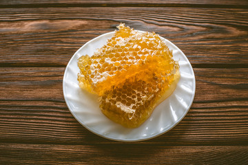 honey in honeycombs on a white plate 