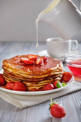 Pancakes with fresh strawberries and jam.